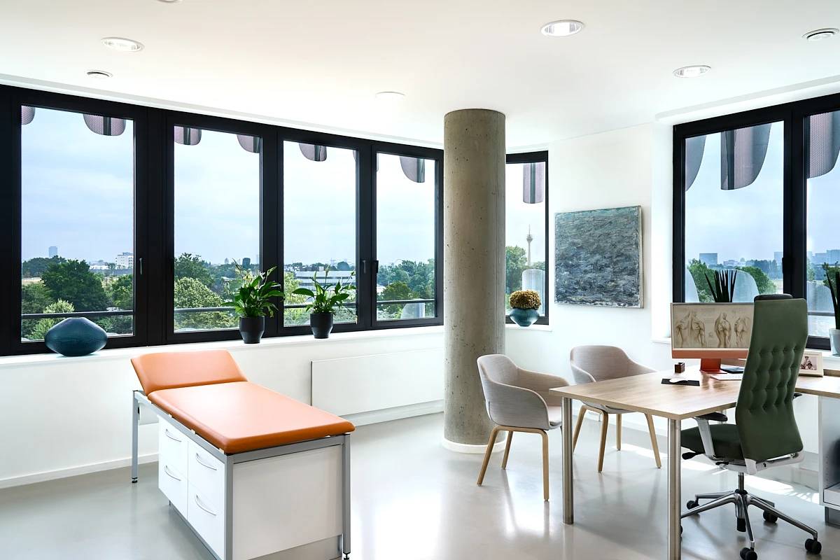 Behandlungszimmer der RKM 740 Wirbelsäulen- und Neurochirurgie Behandlungszimmer der RKM 740 Wirbelsäulen- und Neurochirurgie in Düsseldorf mit Untersuchungsliege und Blick Richtung Rhein
